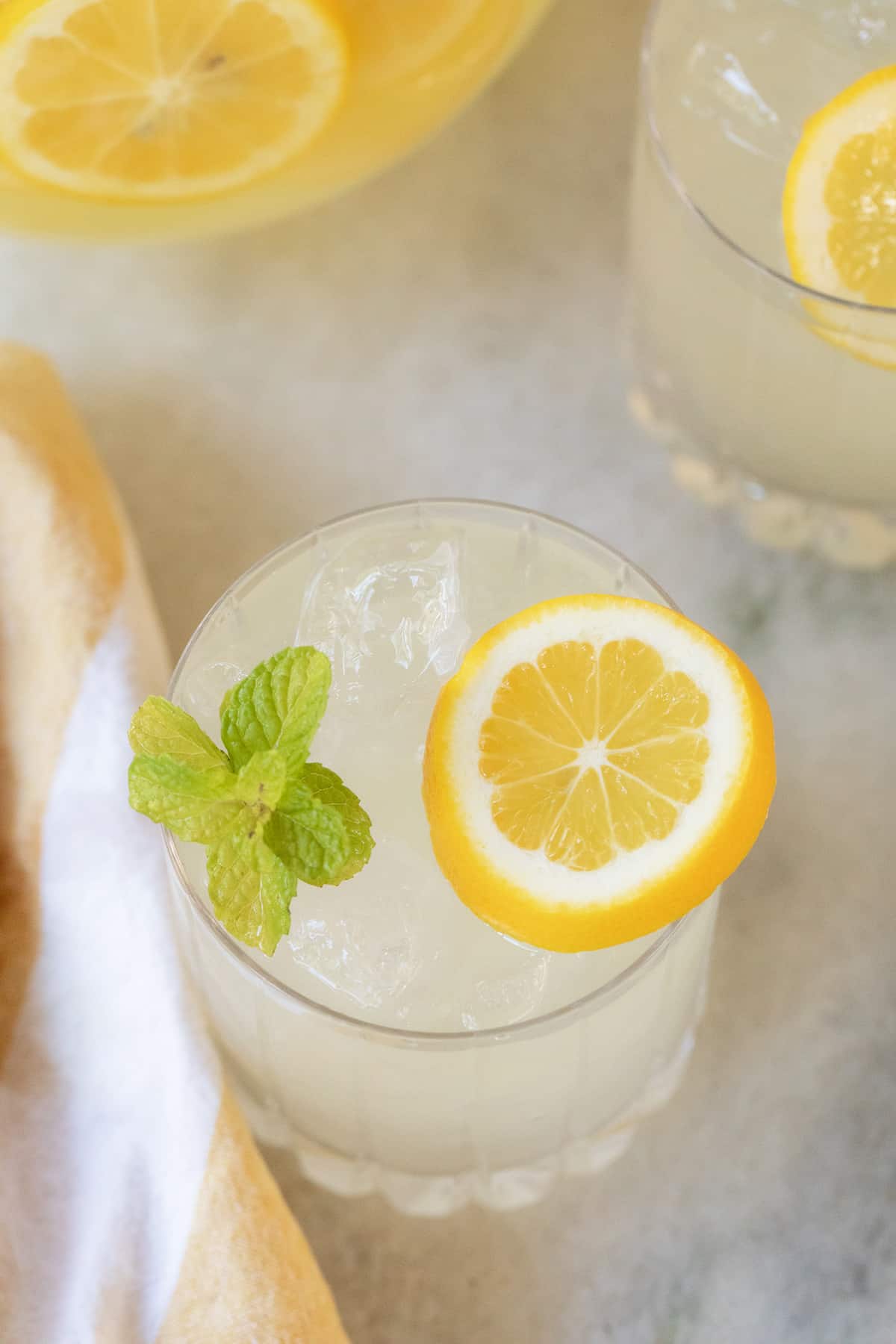 Glass of fresh homemade mint lemonade with lemon slices and mint sprigs,