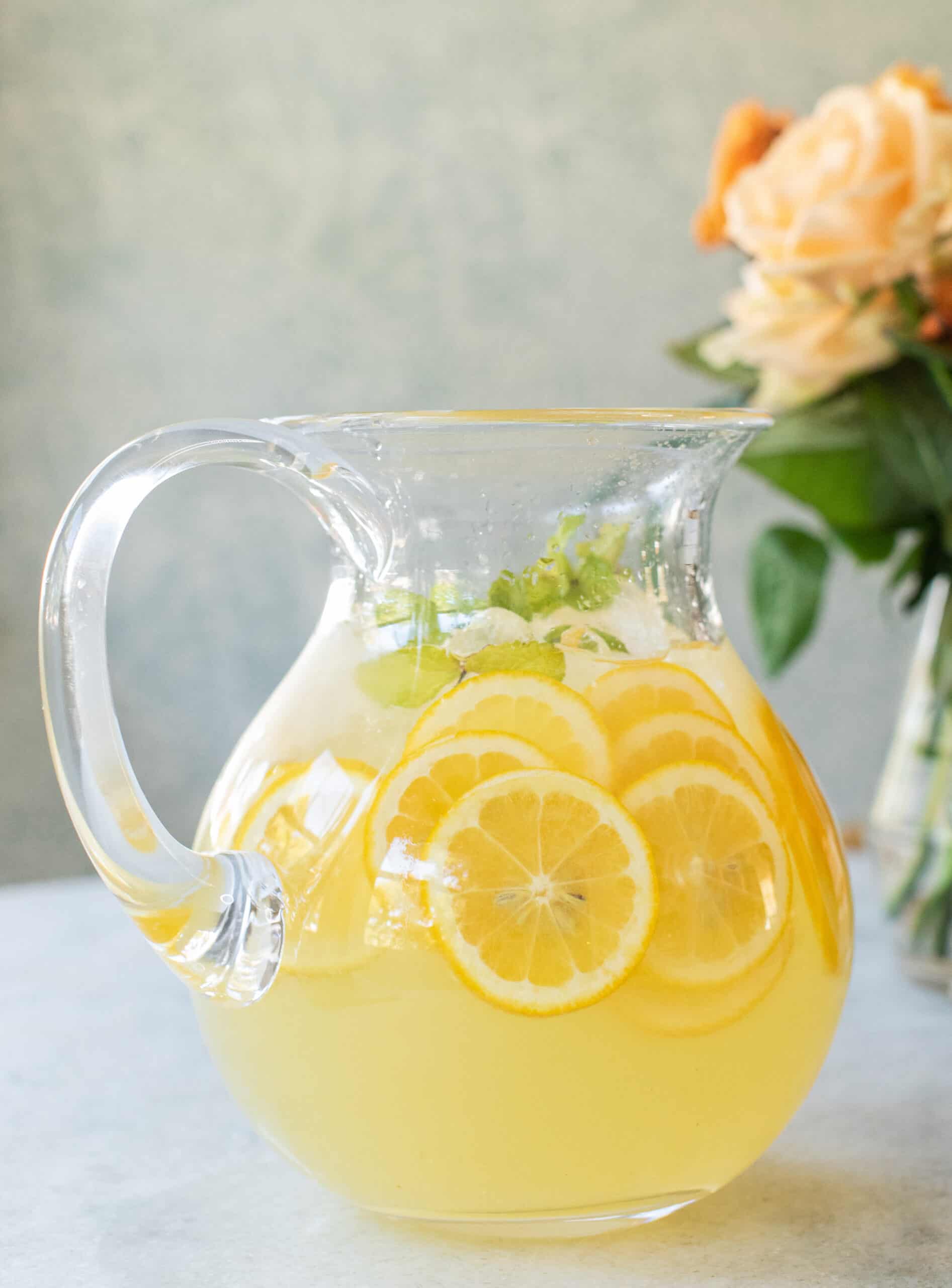 A pitcher of mint lemonade with lemon slices. 