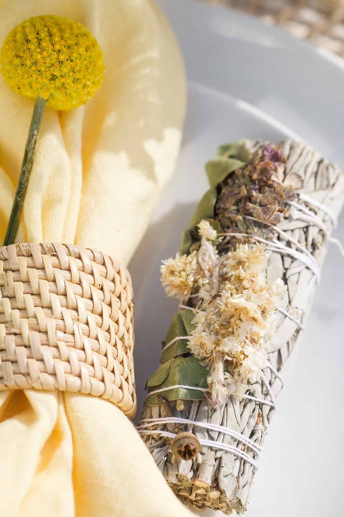 Sage bundles on napkins for a spring party.