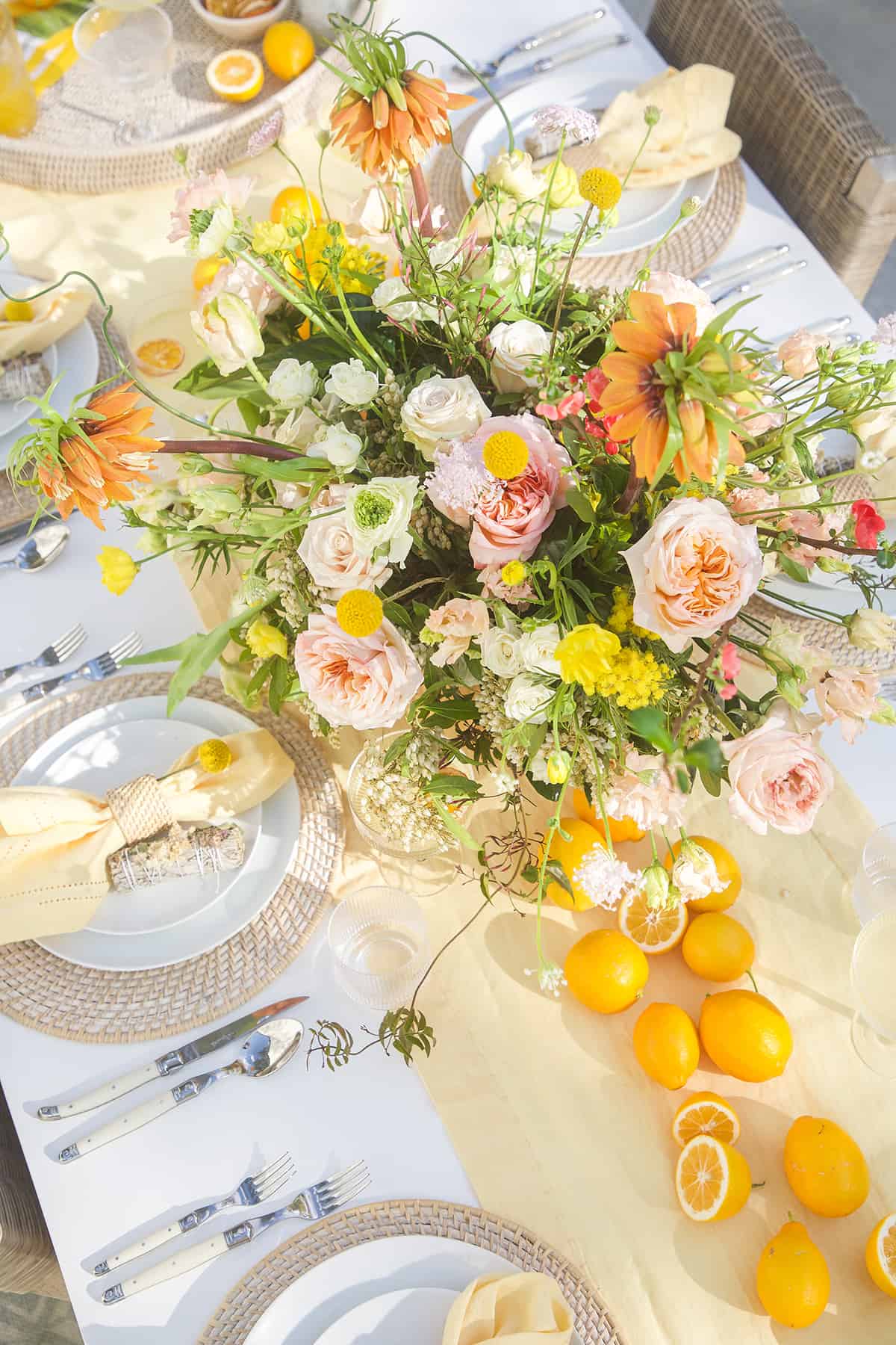 Lemon themed table setting with lemons and flowers.