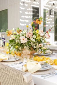 Spring table setting with yellow flowers and lemons.