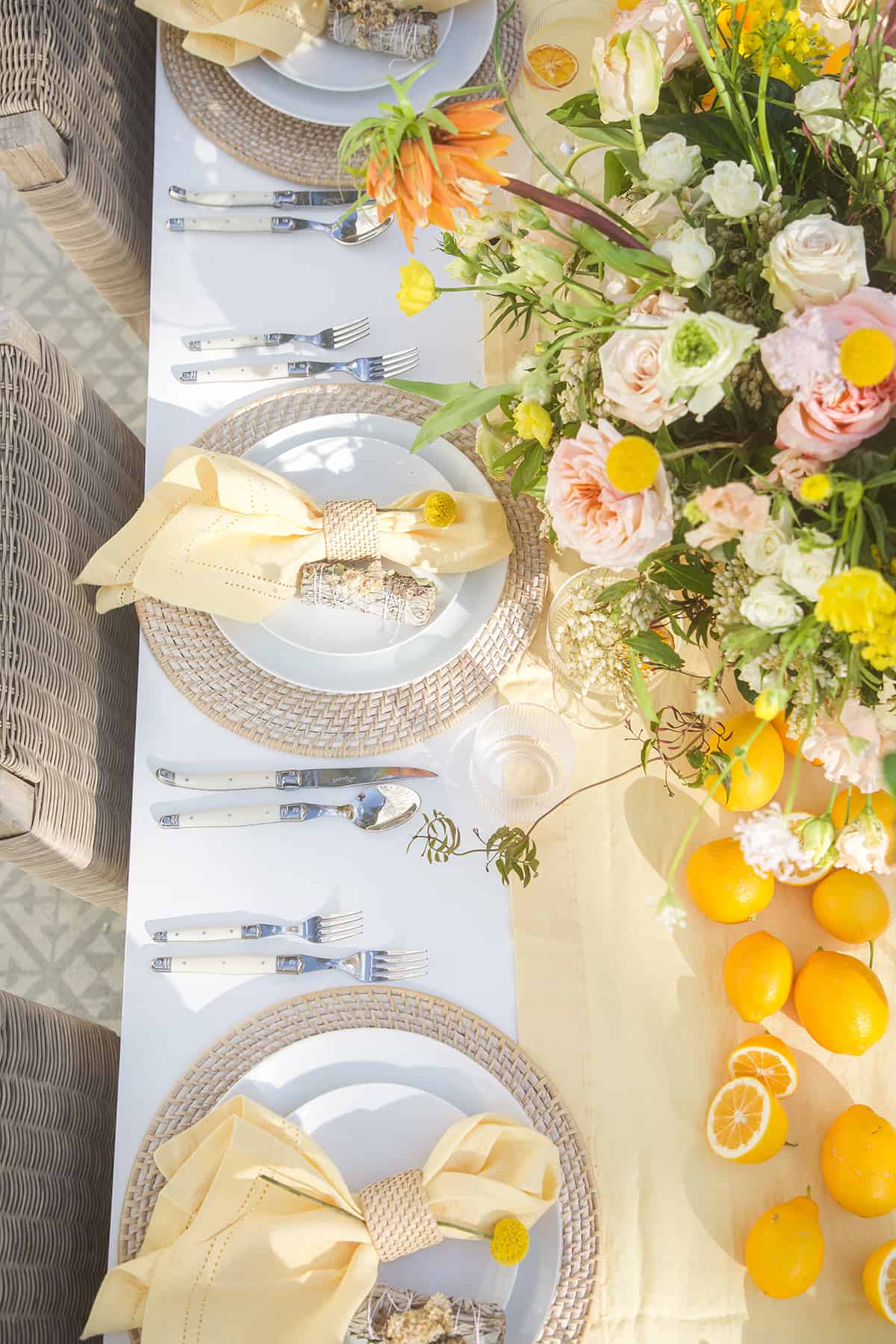 Beautiful spring table setting with plates, chargers, napkins and flowers.