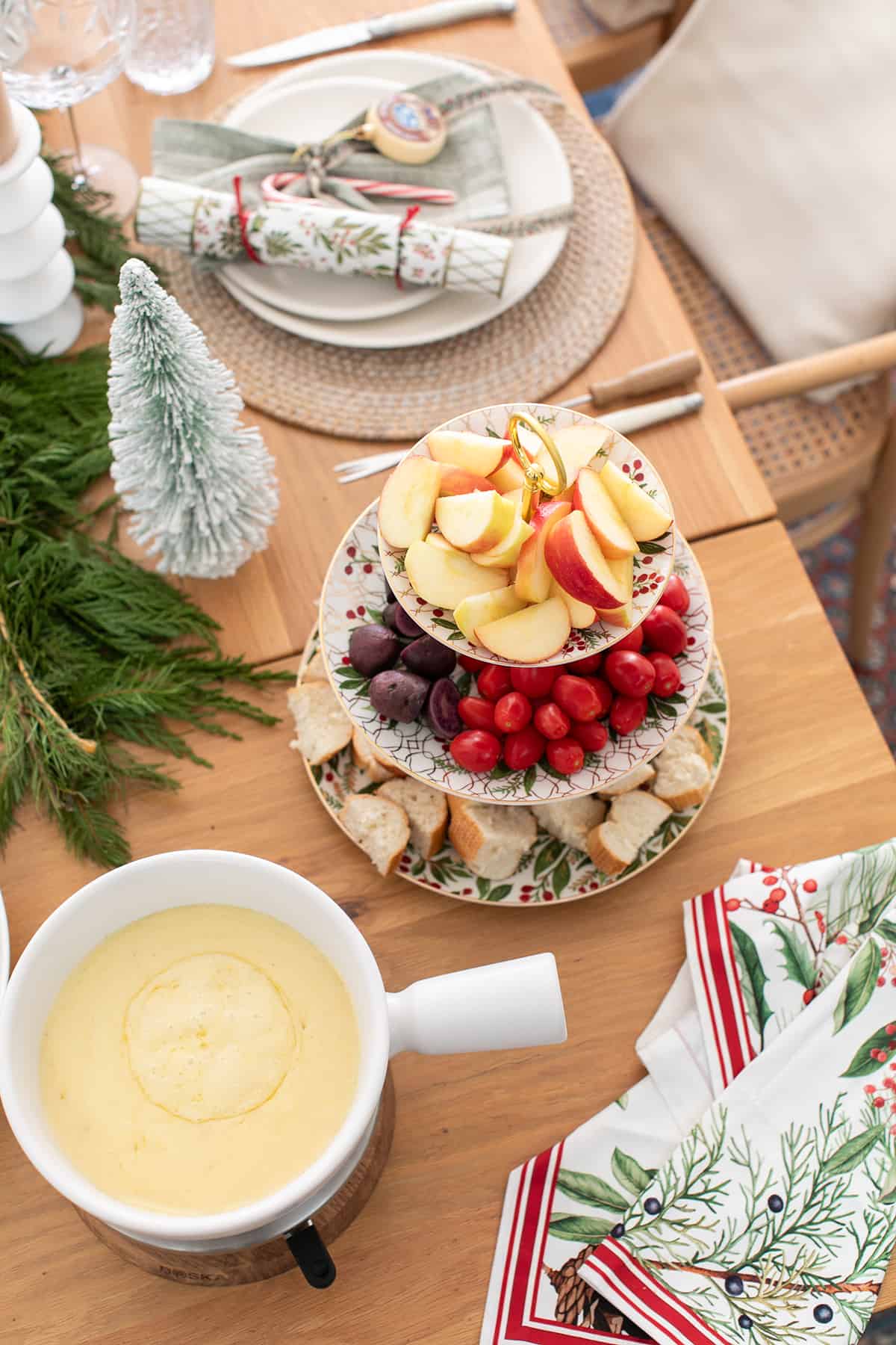 Holiday fondue party with melted cheese and vegetables on a tray.