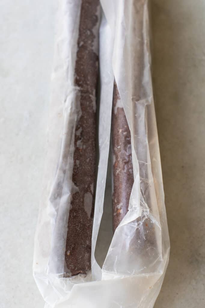 Chocolate cookie dough wrapped in parchment paper.