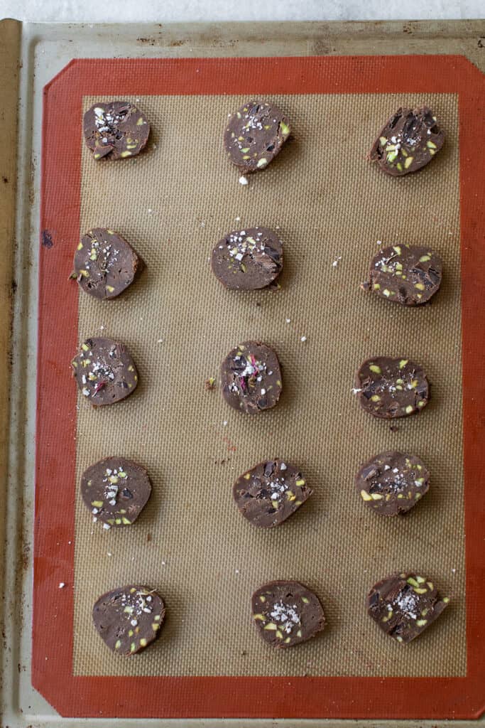 Chocolate pistachio sable cookies before being baked, lined on a silpat cookie sheet.