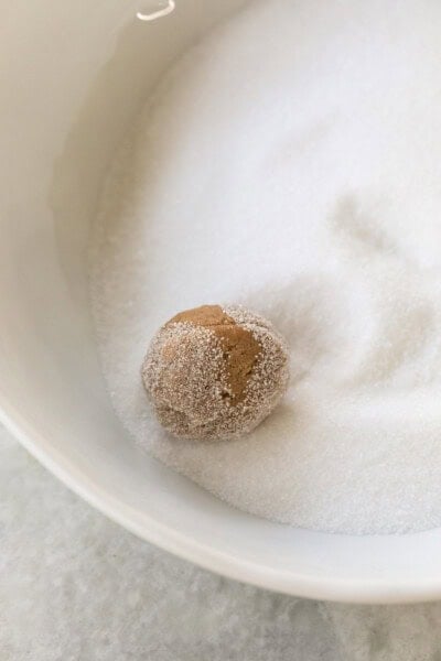 Rolling a gingersnap cookie in sugar.