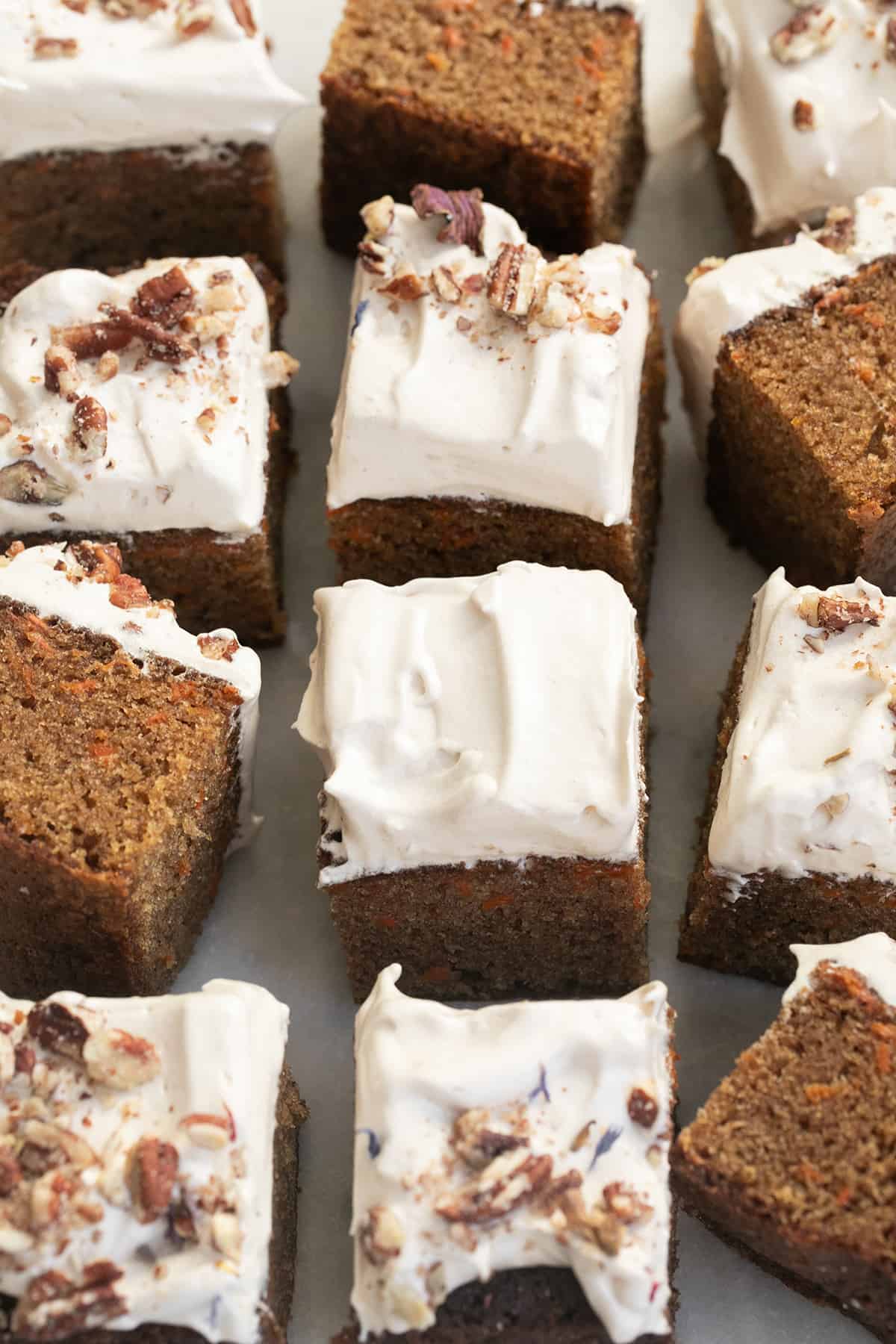 Slices of moist carrot cake with maple syrup frosting.