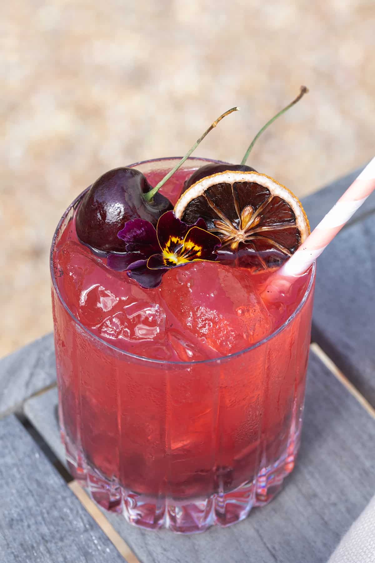 Easy summer cocktail recipe with cherries, lemon, gin and soda water.