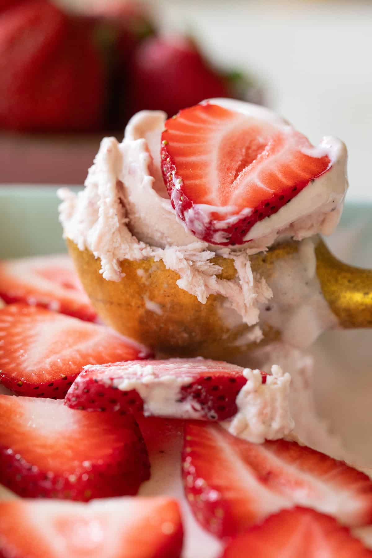 Scoop of creamy, no-churn strawberry ice cream with fresh strawberries.