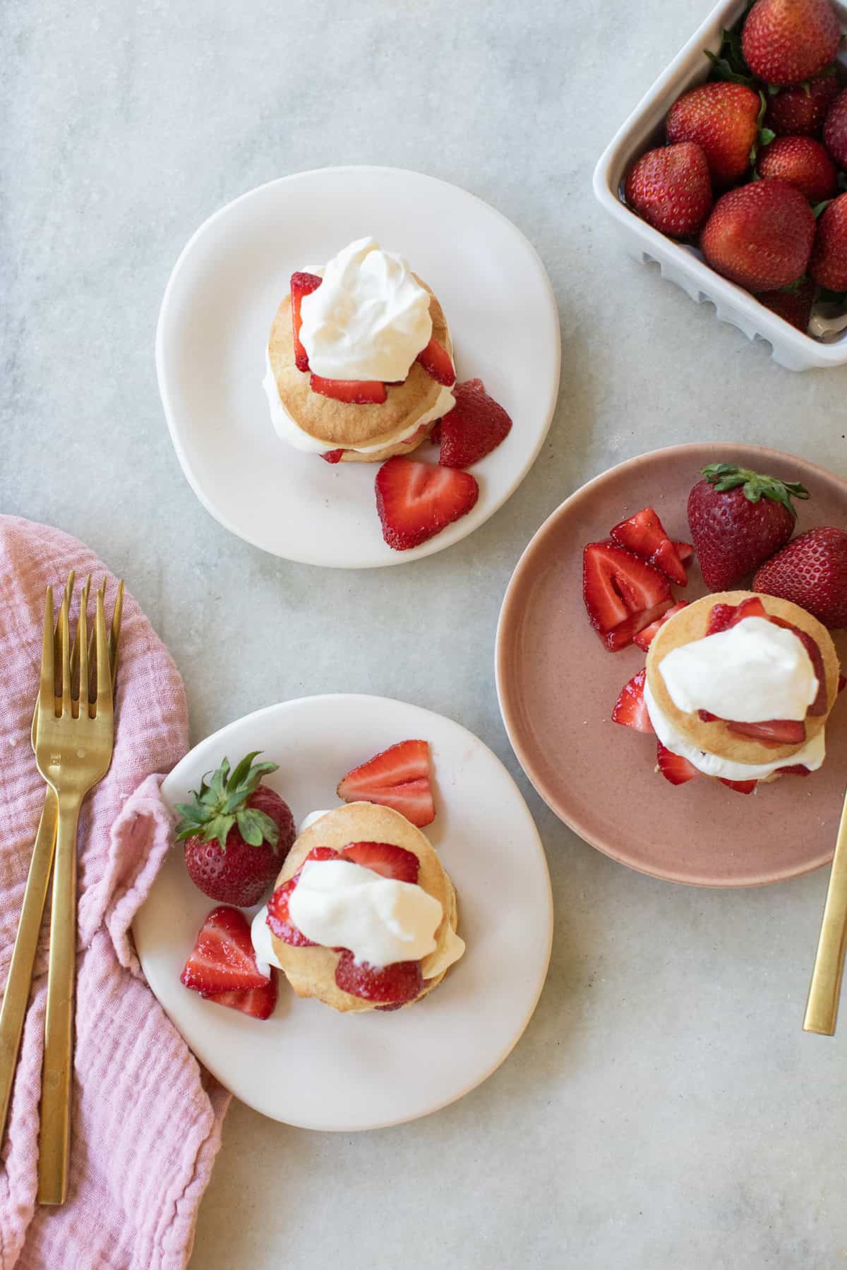 Strawberry shortcakes on a marble table.