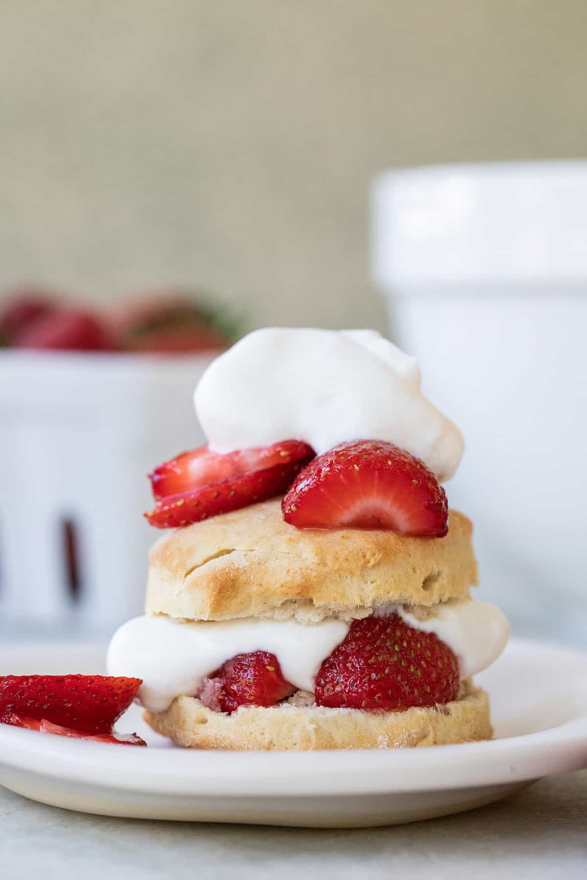 Homemade biscuits stacked with strawberries and whipped cream. 