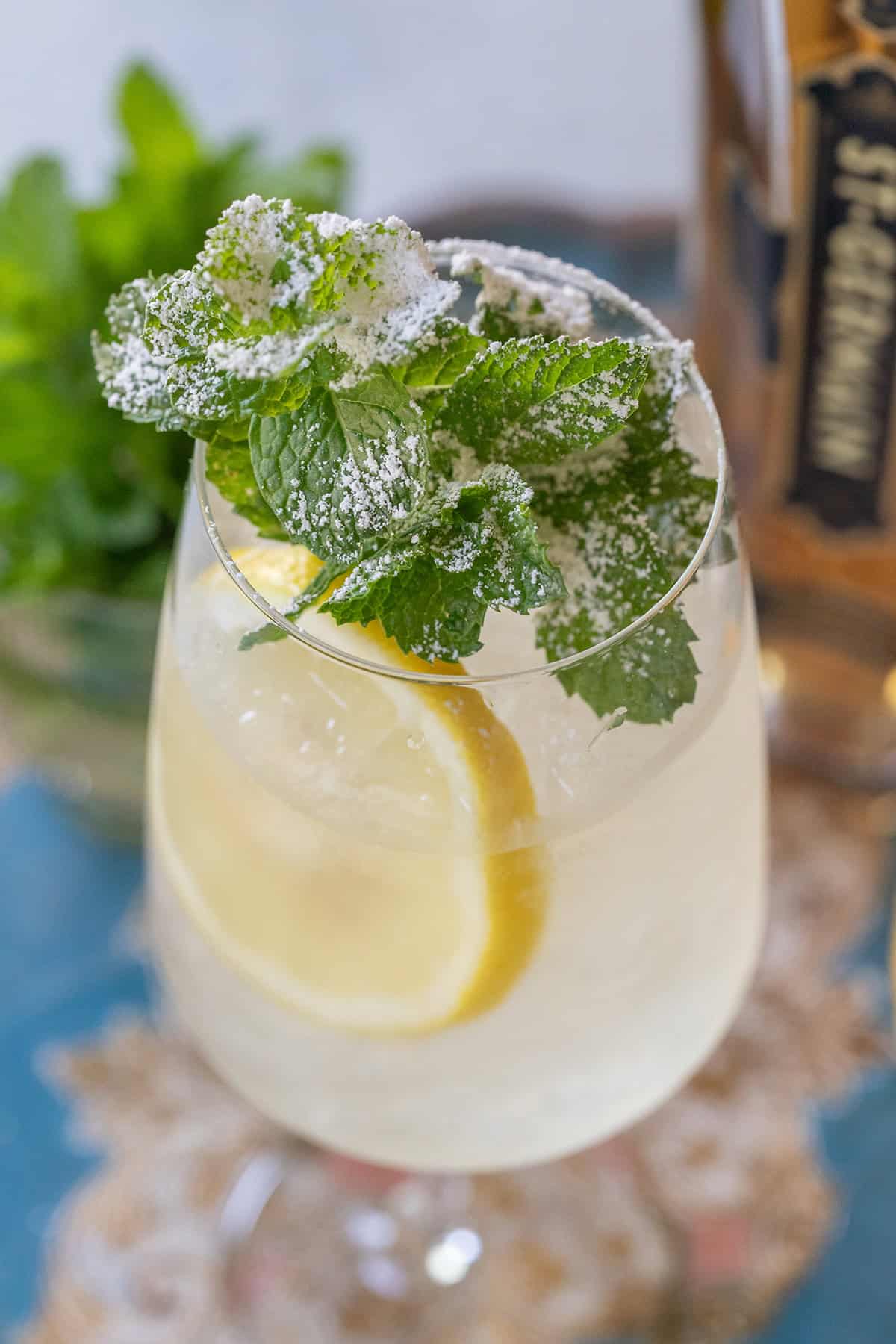 Elderflower spritz with fresh mint and a powdered sugar garnish. 