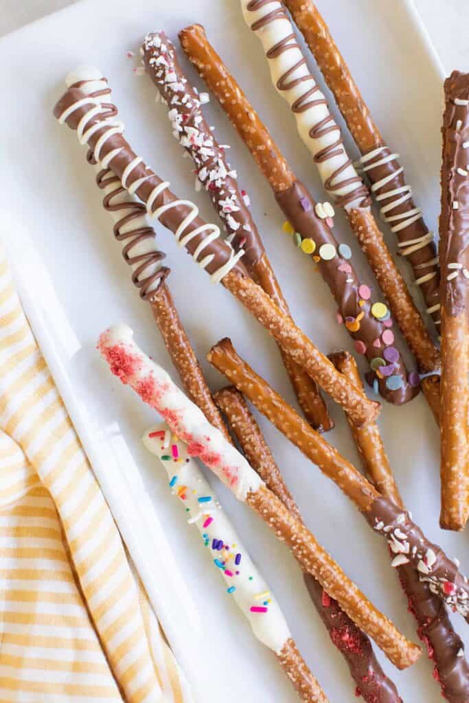 Place dipped pretzels on the prepared baking sheet and sprinkle with decorations while the chocolate is still wet.