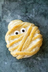 Baked mummy brie with gooey cheese and sprinkle eyes.