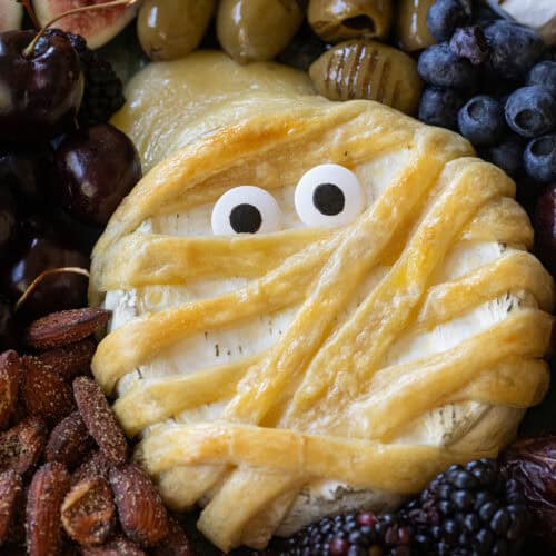 Mummy brie with eyes on a cheese platter.