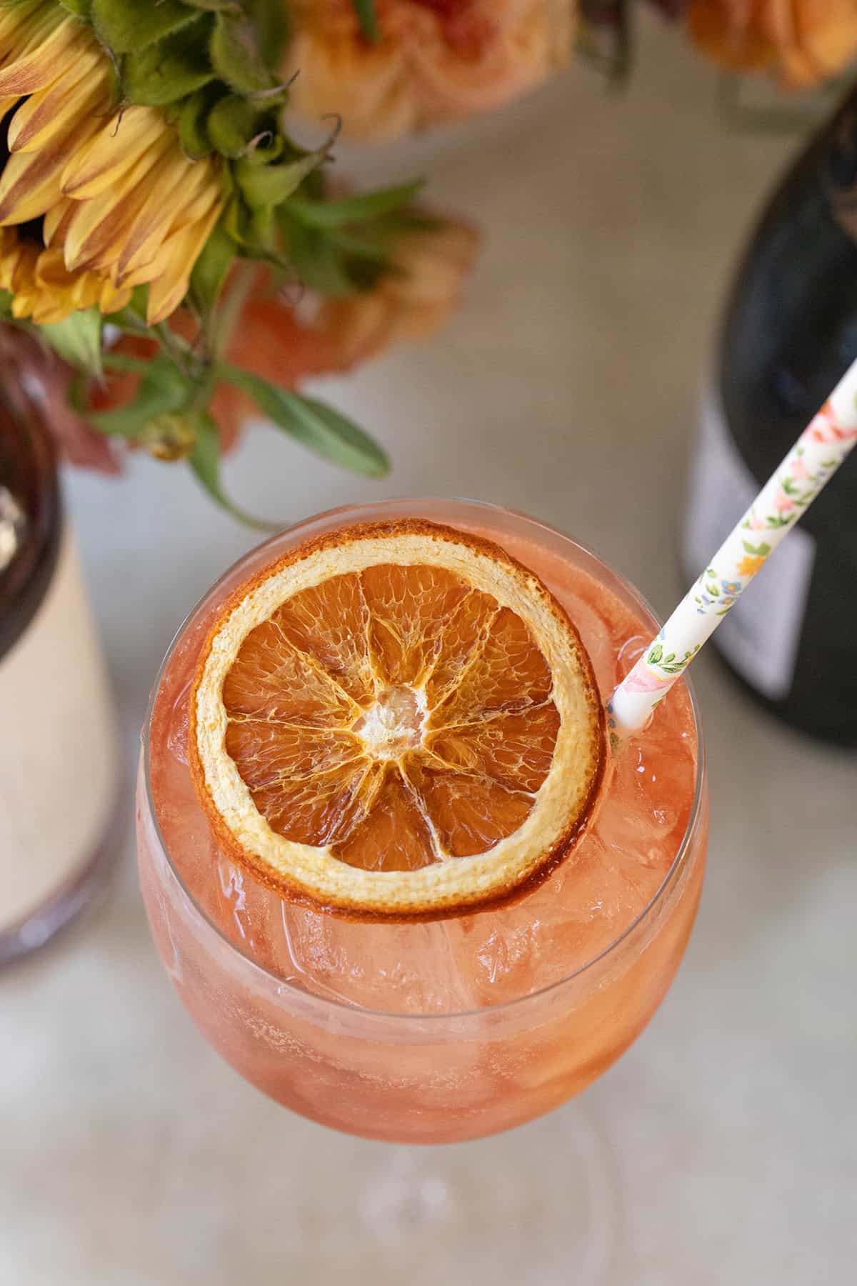 Aperol spritz mocktail in a glass with a dried orange slice.