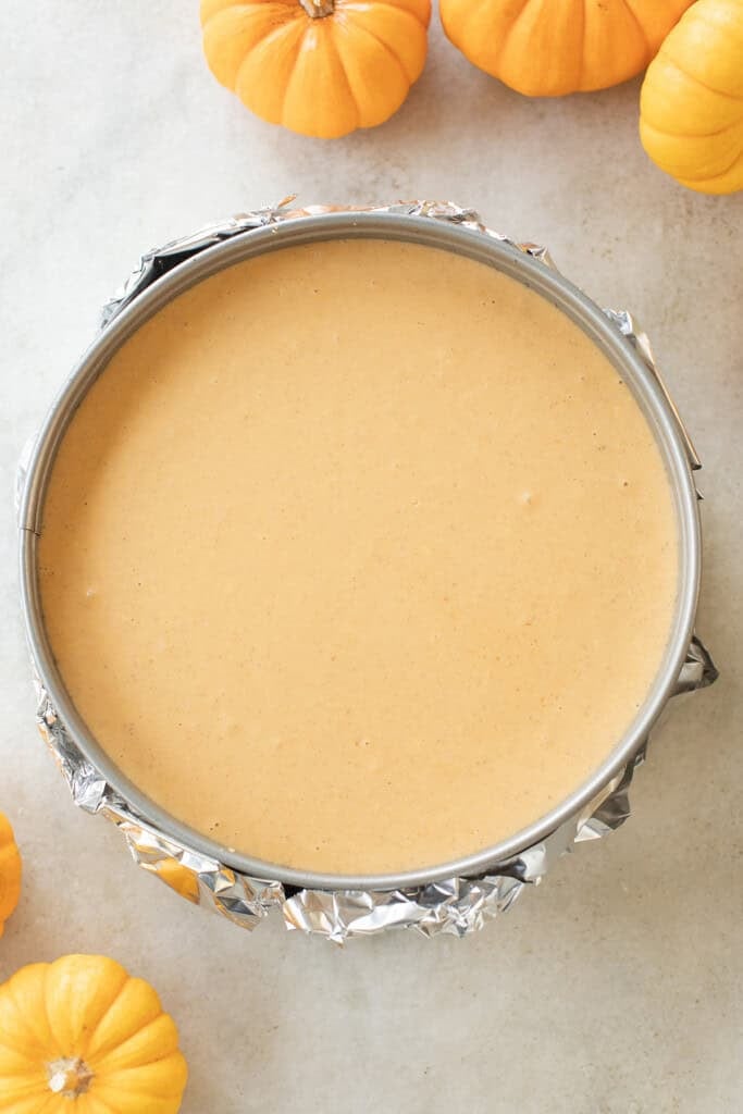 Pumpkin cheesecake in a springform pan before baking.