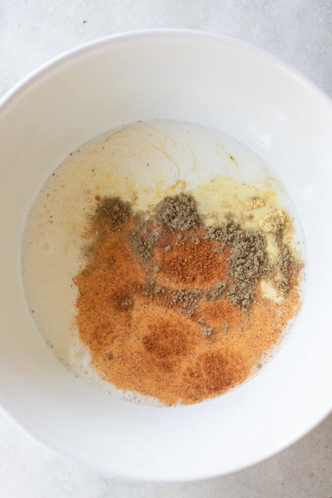 Milk, eggs, and spices in a bowl.