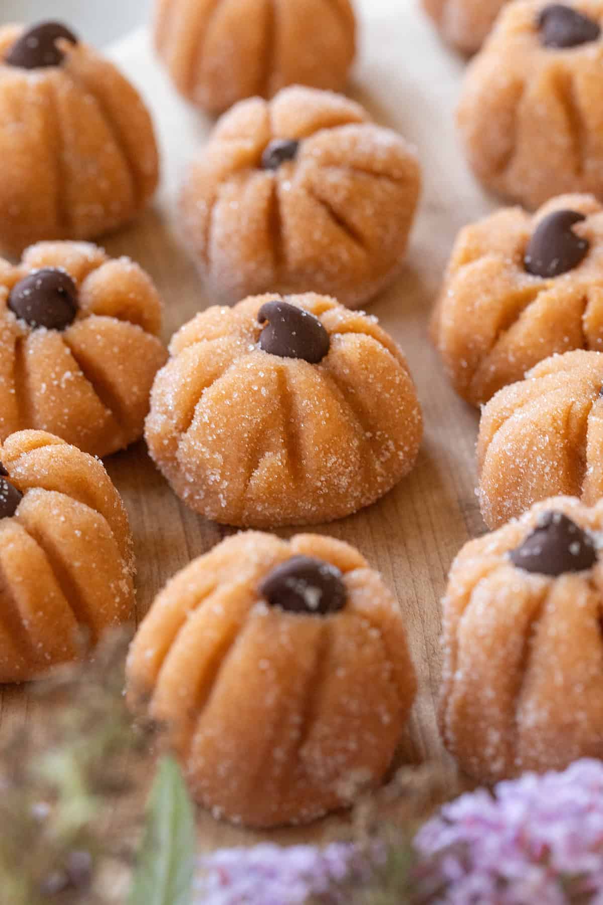 The cutest mini pumpkin cheesecake truffles with chocolate chips.