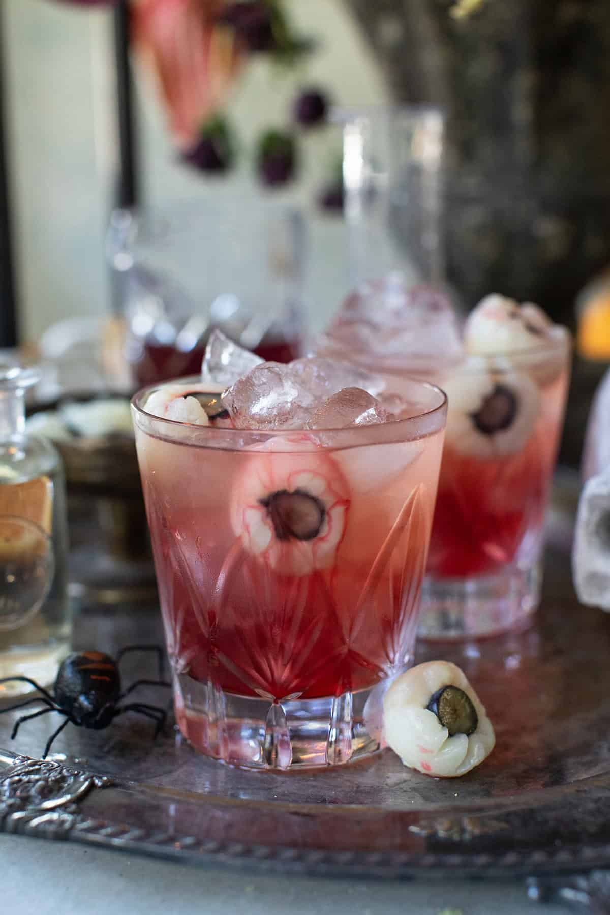 Halloween spooky cocktail recipe with cranberry and lychee eyeballs. 