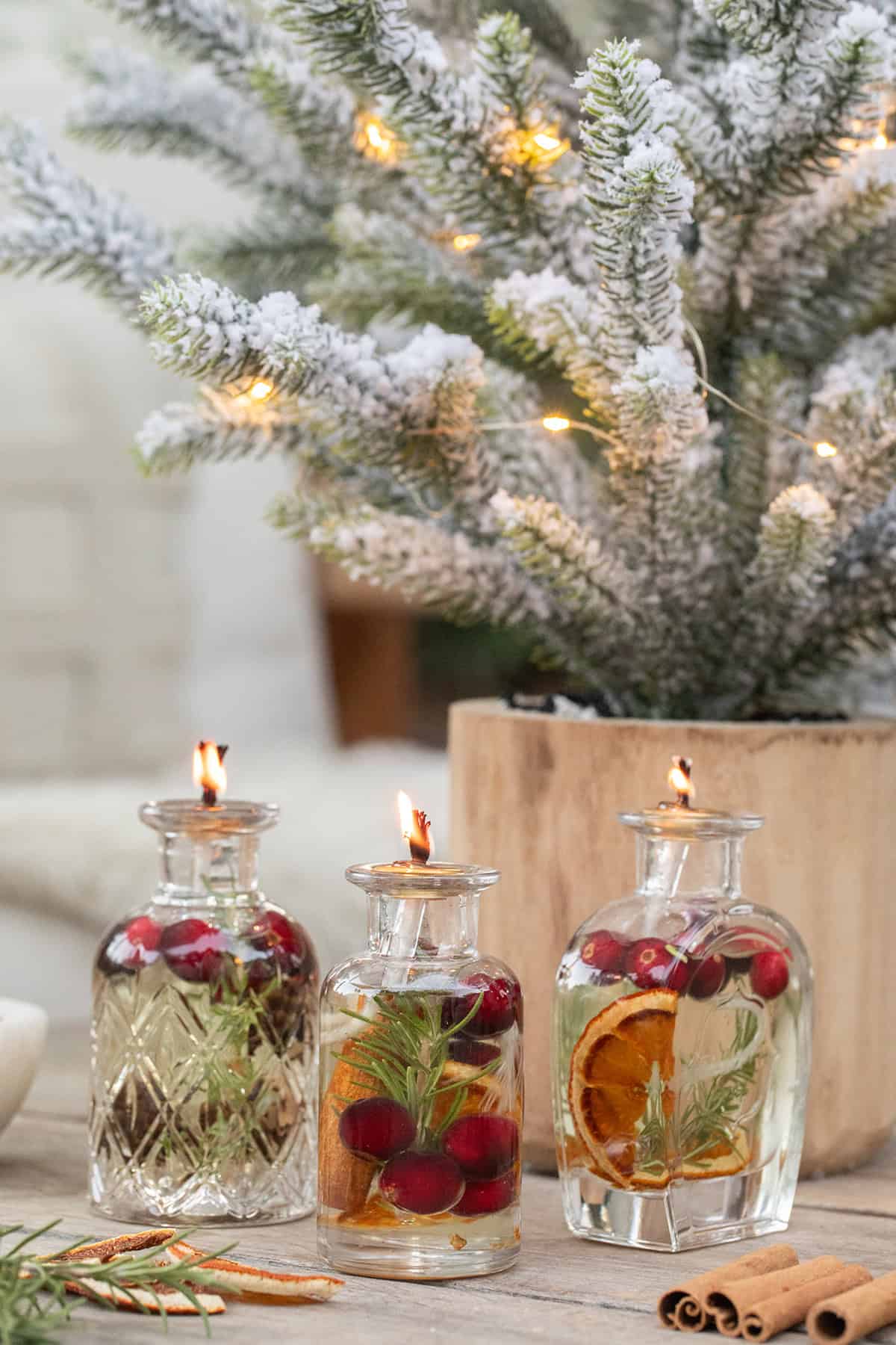 Olive oil candles for a Christmas party filled with berries and rosemary to make them look nice.