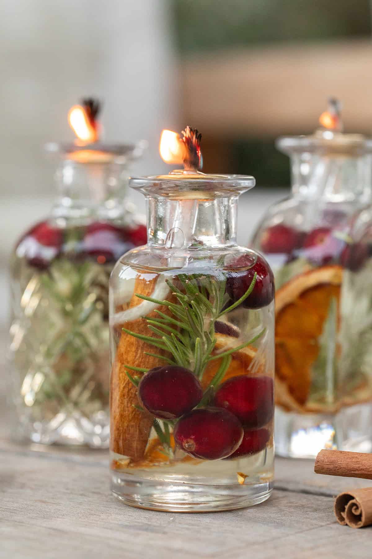 Oil candles with berries, cinnamon, and orange slices. Lit for a cozy glow.