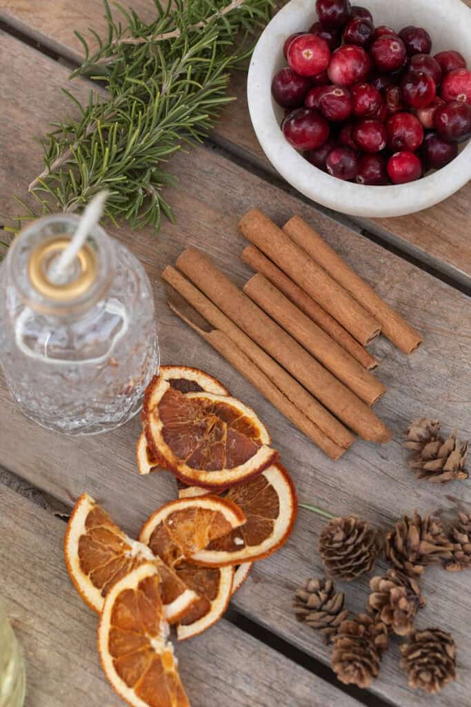 Dried orange slices, cinnamon sticks, berries, and pine cones. 