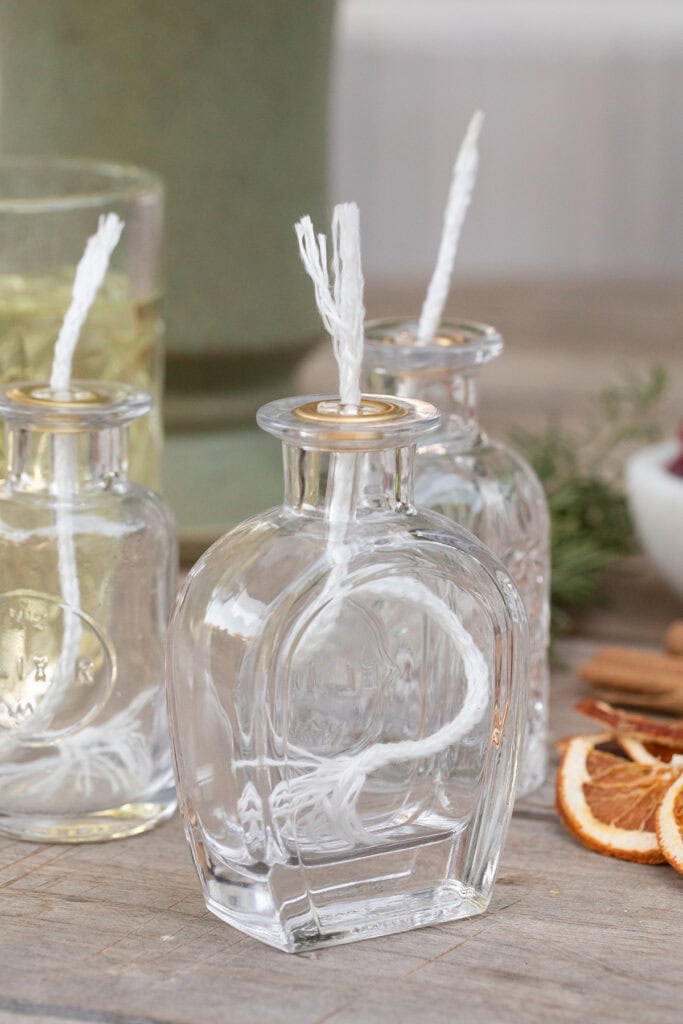 Jars with wick and a jar full of oil to make oil candles. 