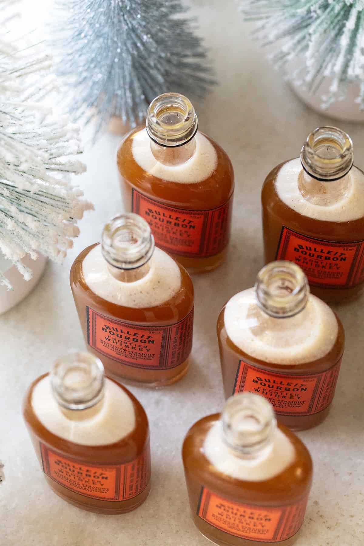 Festive Christmas shots served in bourbon bottles.