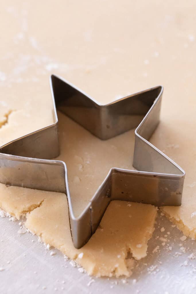 Using a star cookie cutter to make cookie shapes.