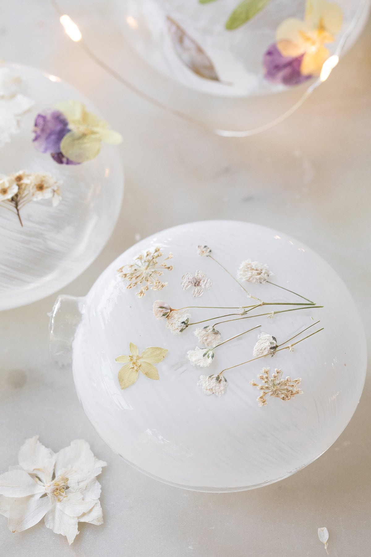 Dried flowers on glass ornaments glued on using Mod Podge. 