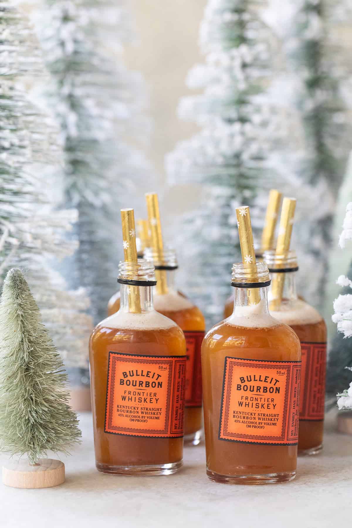 Bourbon gingerbread shots served in small bourbon bottles with a straw.