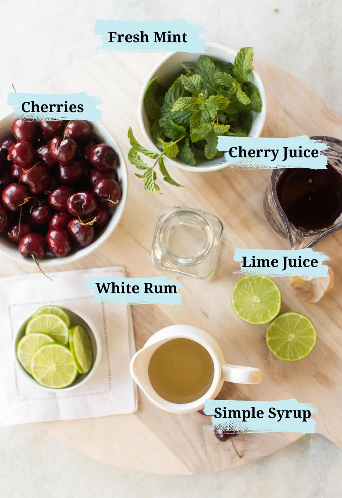 White rum, lime juice, cherry juice, simple syrup and mint leaves in bowls.