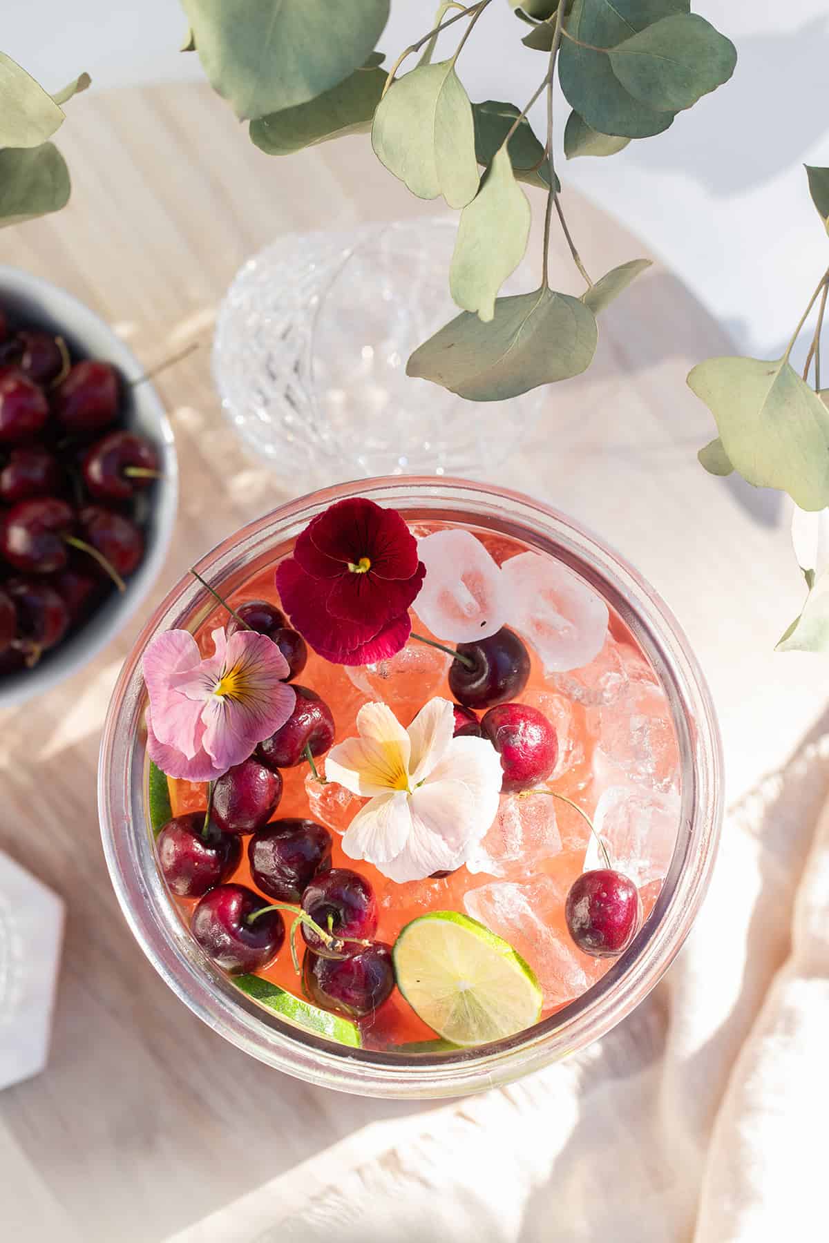 Cherry punch recipe with gin in a large glass container.