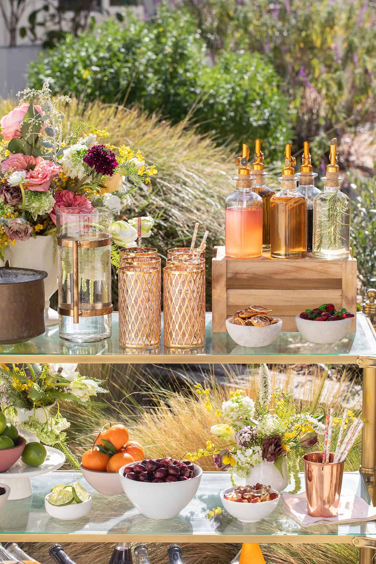 DIY soda bar with glasses, syrups, fruit, flowers and more.