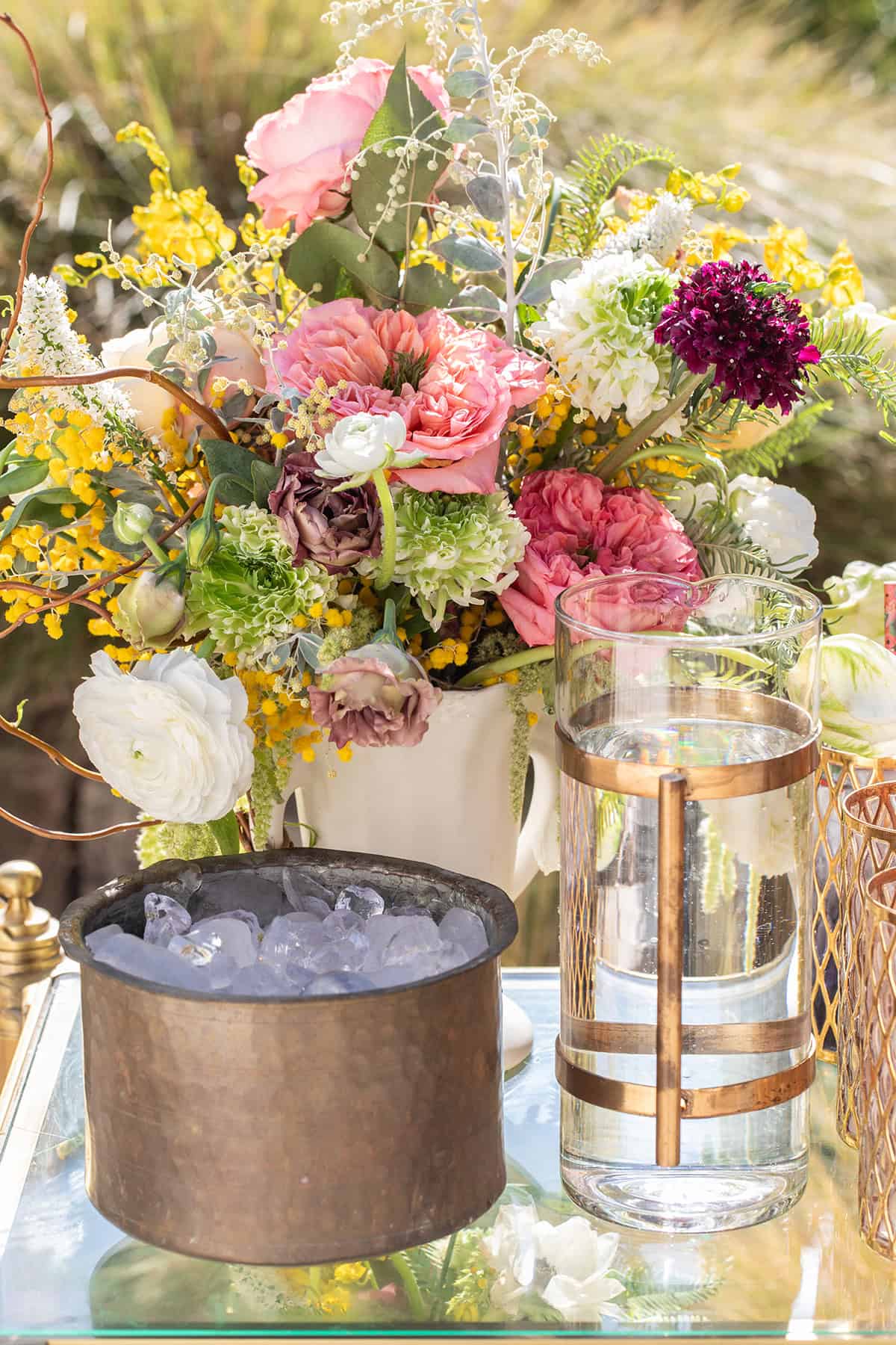 Flowers, sparkling water, ice on a bar cart to make homemade sodas at a party.