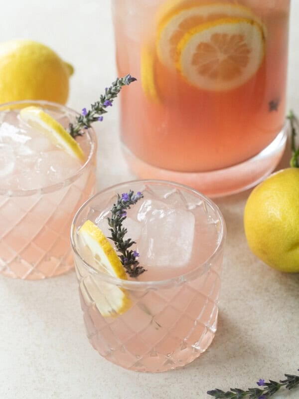 Lavender lemonade in glasses with lemons and fresh lavender.
