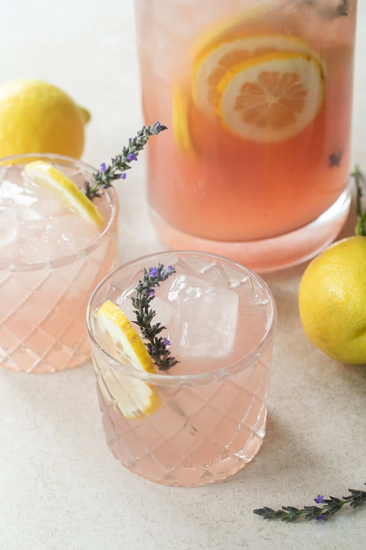 Lavender lemonade in glasses with lemons and fresh lavender.
