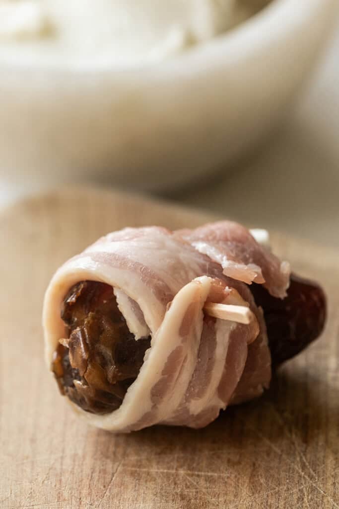 Bacon wrapped around a date that is stuffed with goat cheese.