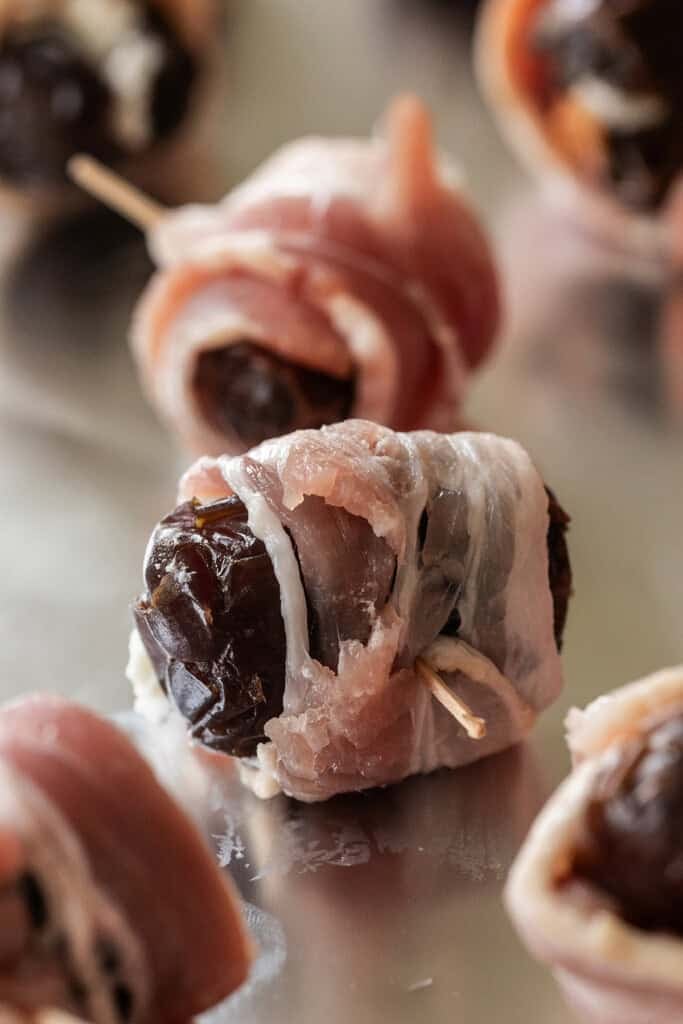 Goat cheese stuffed date wrapped with bacon on tinfoil. 
