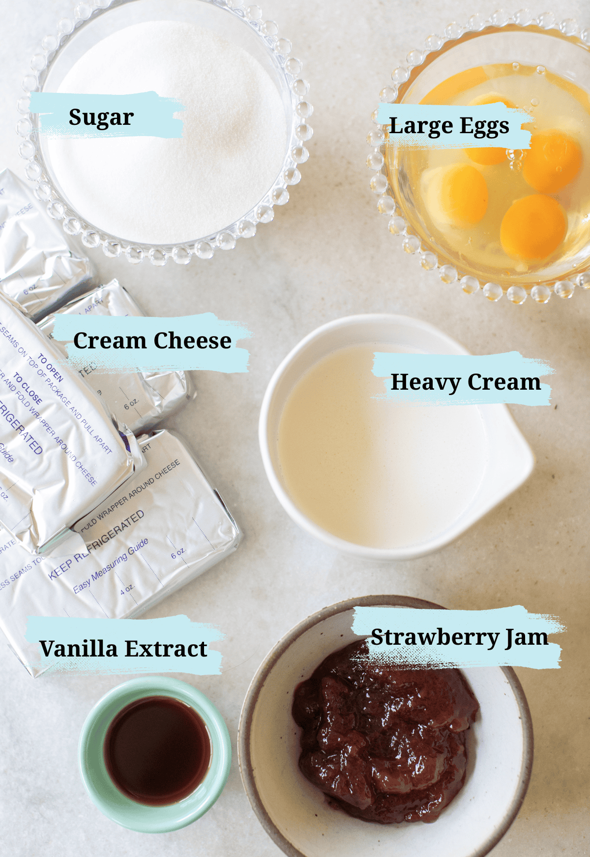 Strawberry cheesecake ingredients in bowls on a table. 