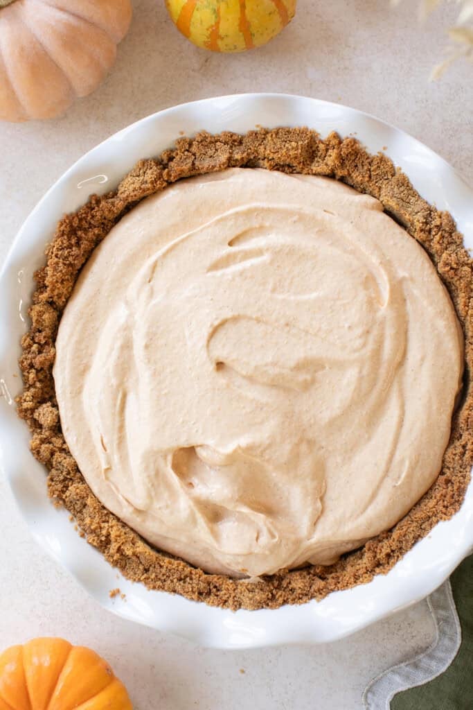 Frozen pumpkin mousse pie in a graham cracker crust pie crust.