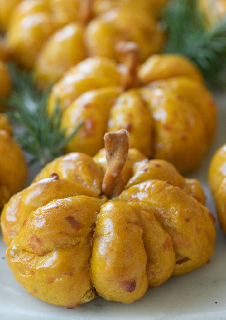 Close-up of soft pumpkin rolls brushed with melted butter.