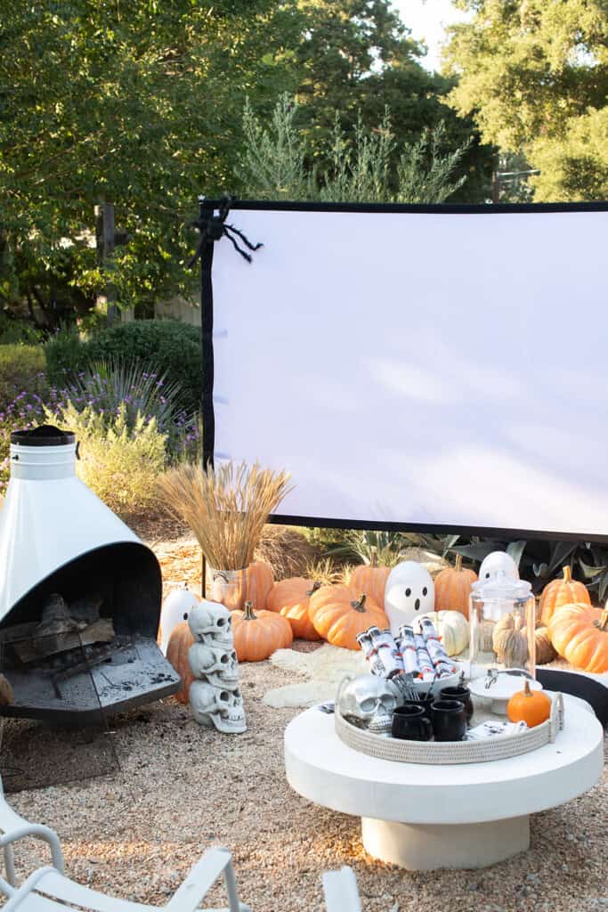 Halloween movie night with pumpkins, a screen and Halloween decor.