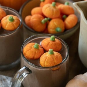 Pumpkin hot chocolate in a mug with pumpkin marshmallows.
