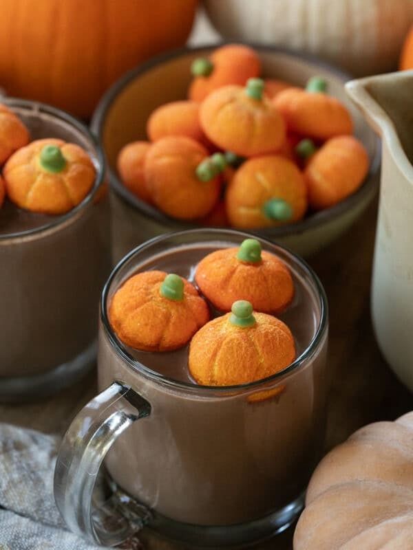 Pumpkin hot chocolate in a mug with pumpkin marshmallows.