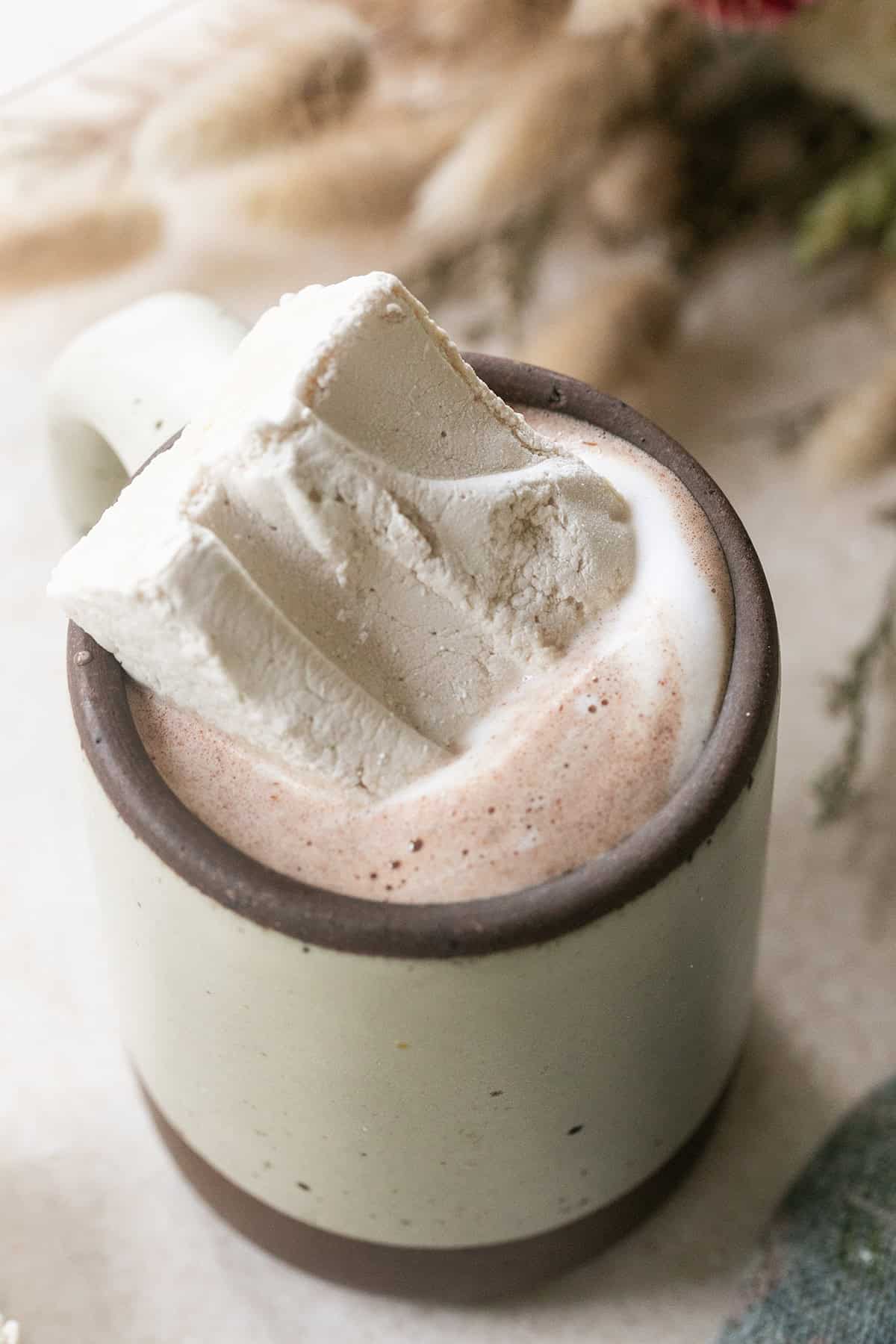 Homemade marshmallow made with maple syrup in a mug of hot chocolate.