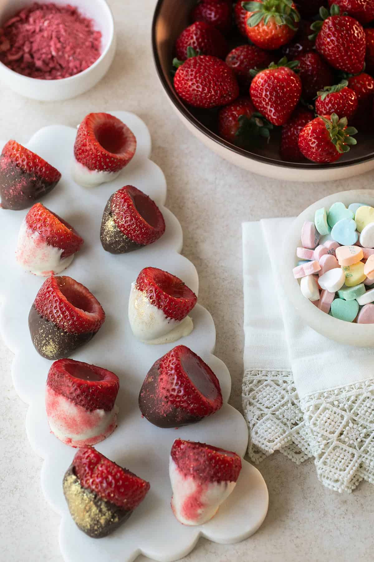 Chocolate-dipped strawberry jello shots with vanilla filling and edible glitter.