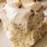 Delicious banana cake topped with cream cheese frosting and fresh bananas.