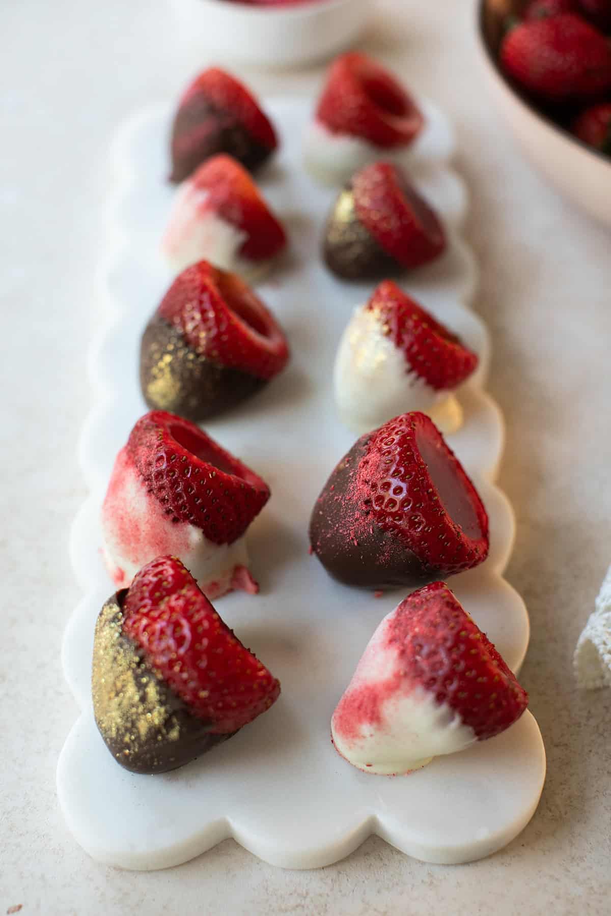 sStrawberry jello shots dipped in white and dark chocolate, decorated with edible gold dust. Perfect for desserts and special occasions.